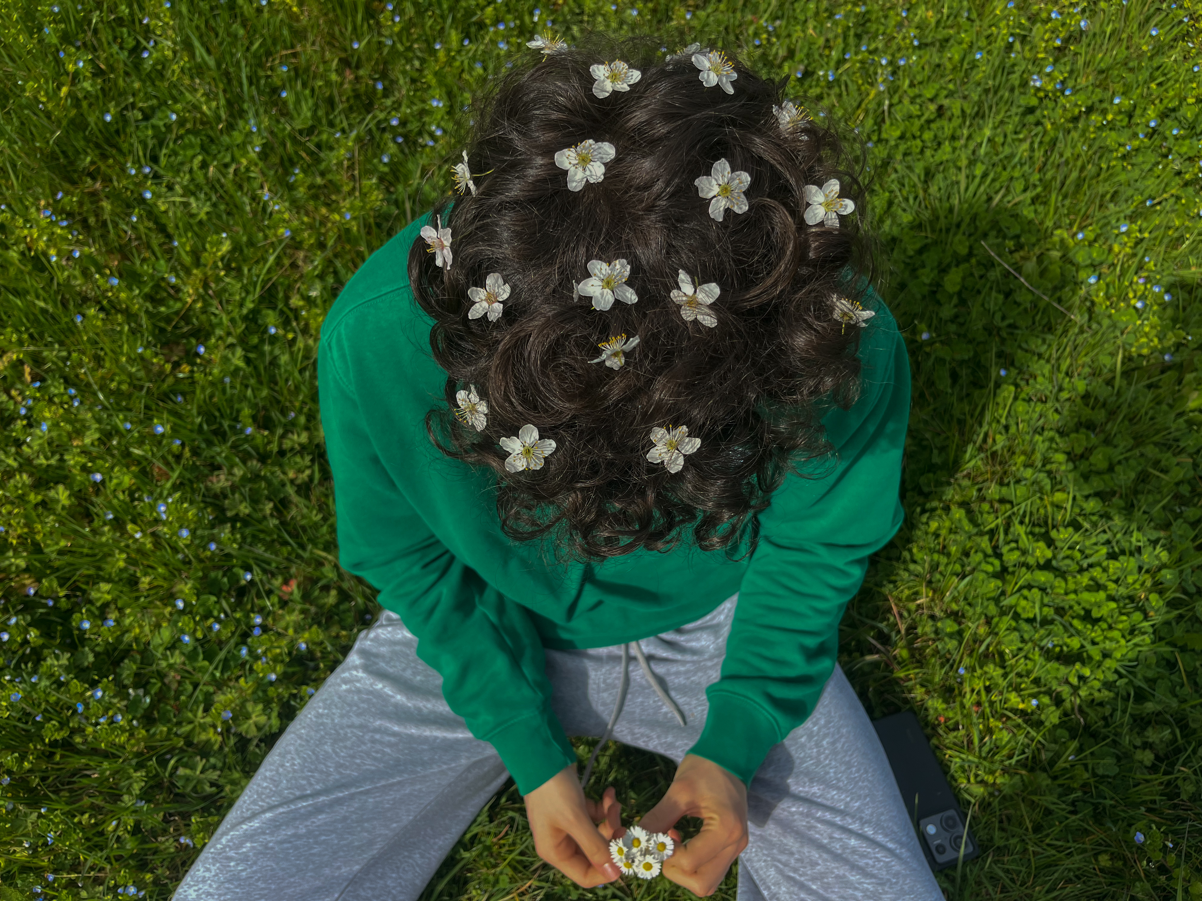 photo d'un homme assis avec des fleurs dans les cheveux